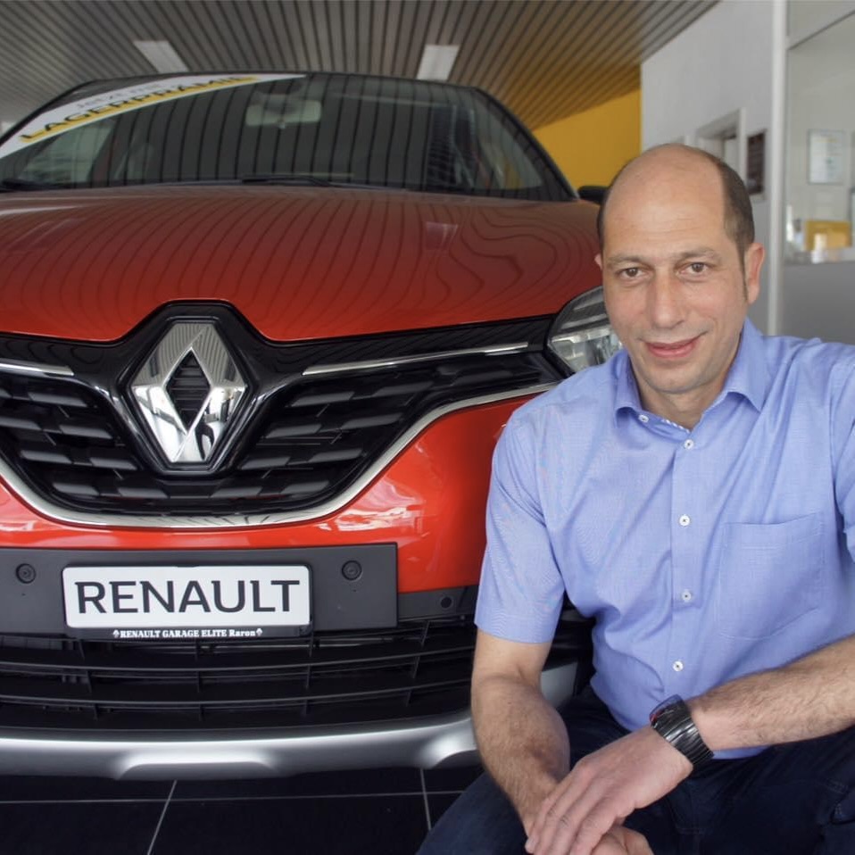 Helmut Walker im Showroom der Garage Elite in Raron neben einem Renault.